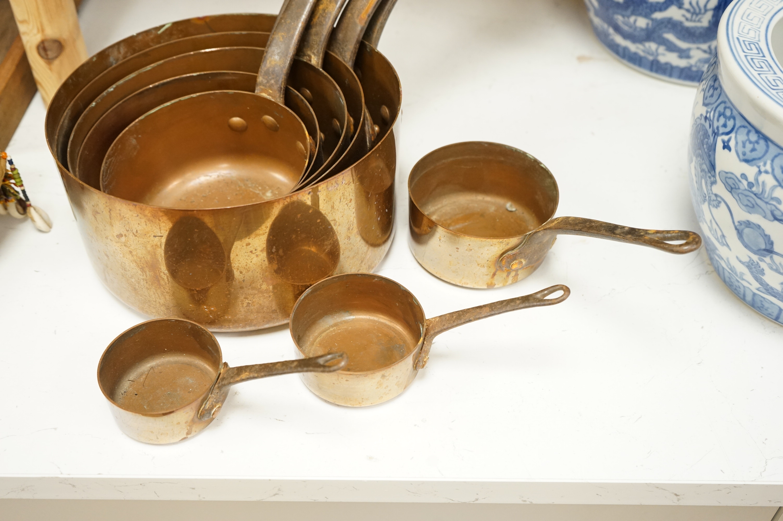 A graduated set of copper saucepans, largest 20.5cm diameter, smallest 6.5cm